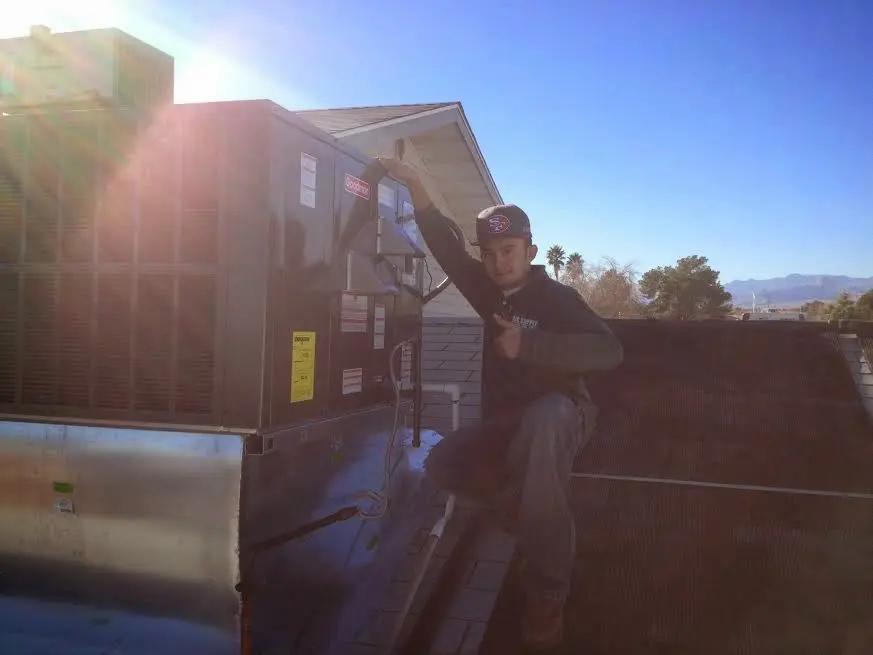 HVAC technician performing AC Tune-Up on a rooftop unit in Wilmington
